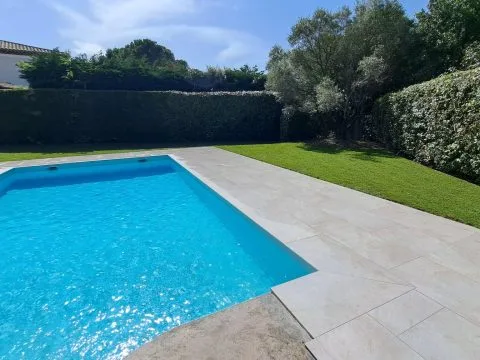 Pose de plaques de pelouse : gazon en plaques posé autour d'une piscine, dalles claires en bordure, photo 7