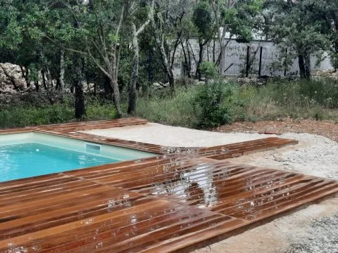 Terrasse pour piscine : platelage en bois exotique autour d'un bassin, en cours de pose, photo 4